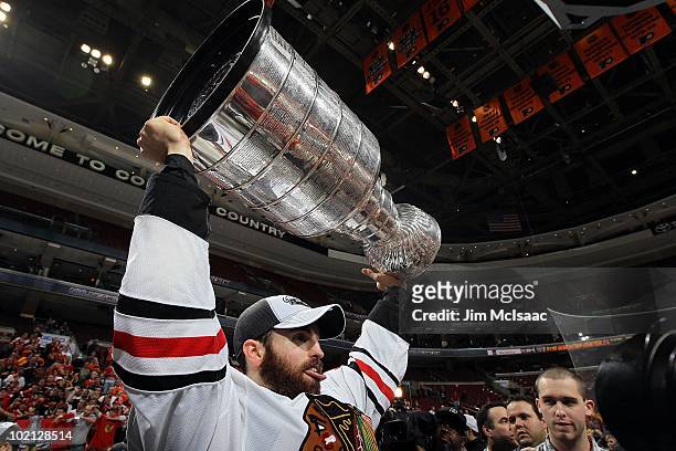 Andrew Ladd of the Chicago Blackhawks hoists the Stanley Cup after teammate Patrick Kane scored the game-winning goal in overtime to defeat the...