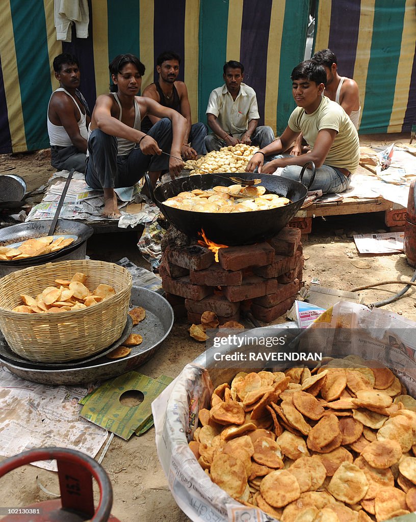 Indian workers prepare food to be handed