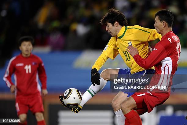 Brazil's midfielder Kaka controls the ball between North Korea's midfielder Mun In-Guk and teammate defender Pak Chol-Jin during their Group G first...