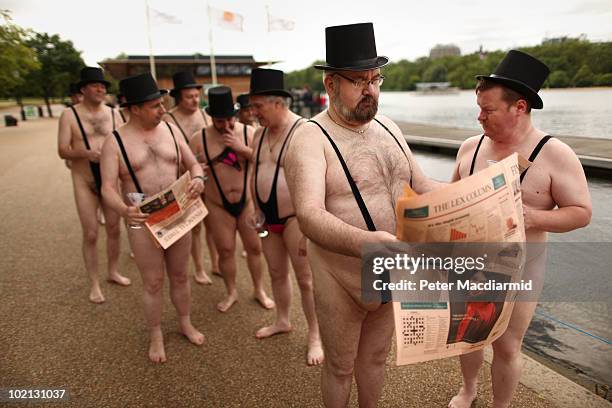 Men dressed as 'greedy businessmen' wearing mankini swimming costumes stand next to the Serpentine Lake in Hyde Park for a mobile phone promotion on...