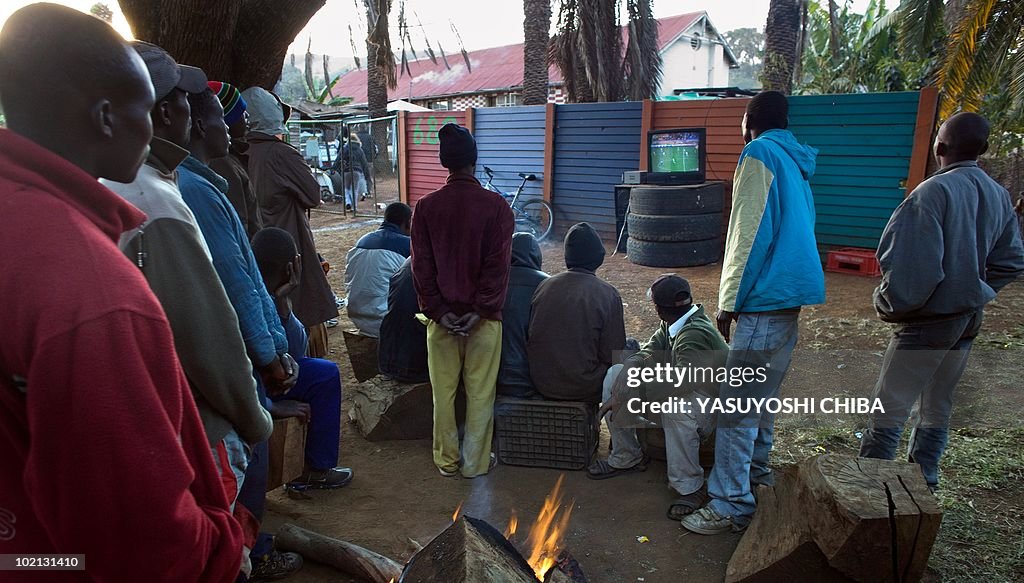 People gather around a television set up