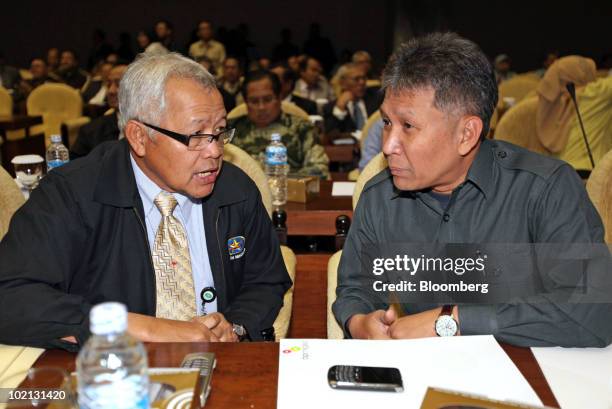 Tubagus Haryono, chairman of pipelines and fuel regulator BPH Migas, left, talks with R. Priyono, chairman of BPMigas, during a hearing on gas prices...