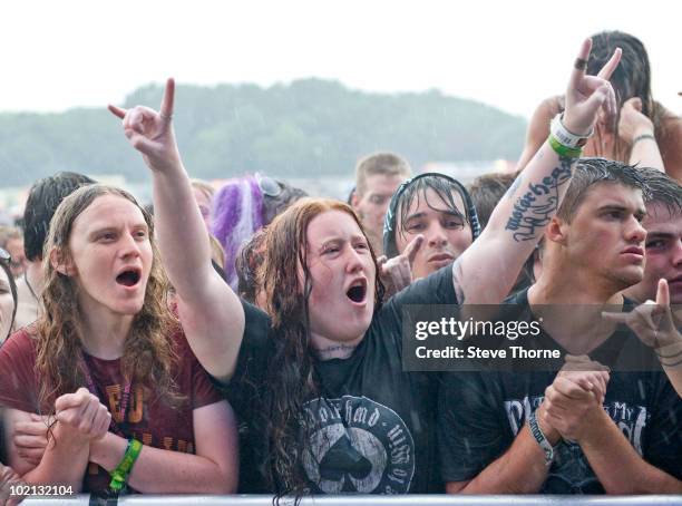 Heavy metal fans in the crowd cheering in the rain while watching Motorhead perform on stage on the last day of Download Festival at Donington Park...