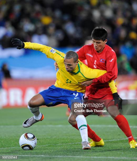 Luis Fabiano of Brazil is defended by Ri Kwang Chon of North Korea during the 2010 FIFA World Cup South Africa Group G match between Brazil and North...