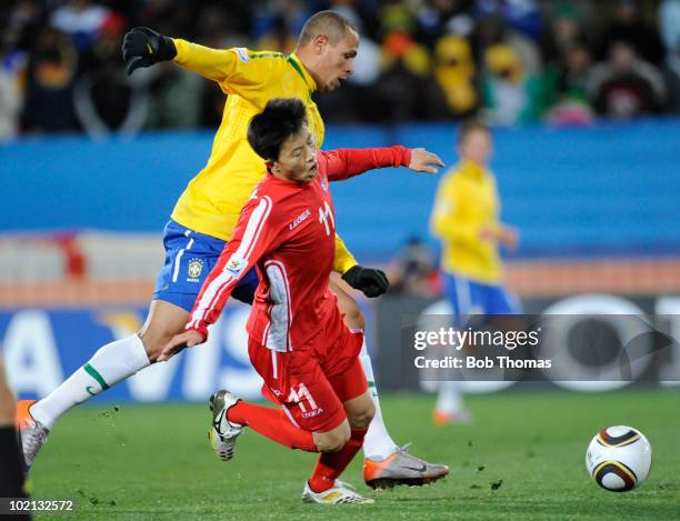 Luis Fabiano of Brazil and Mun In Guk of North Korea battle for the ball during the 2010 FIFA World Cup South Africa Group G match between Brazil and...