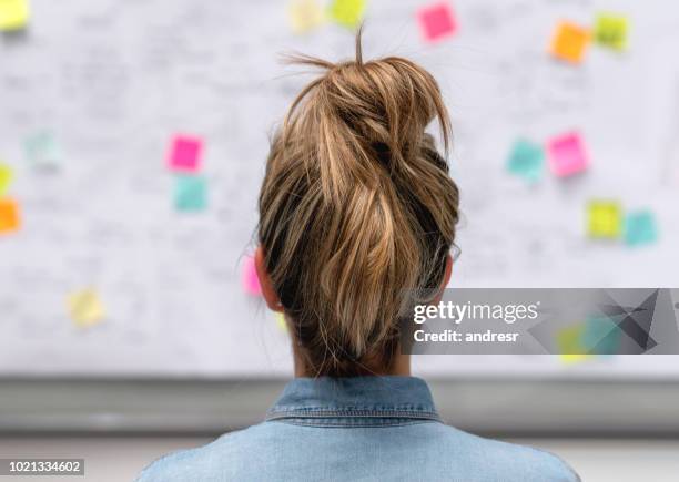 creatieve zakenvrouw brainstormen op kantoor met behulp van een whiteboard - presentatieborden stockfoto's en -beelden