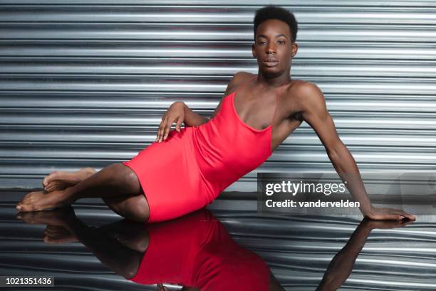 crossdressing man wearing a red dress - industrial doors stock pictures, royalty-free photos & images