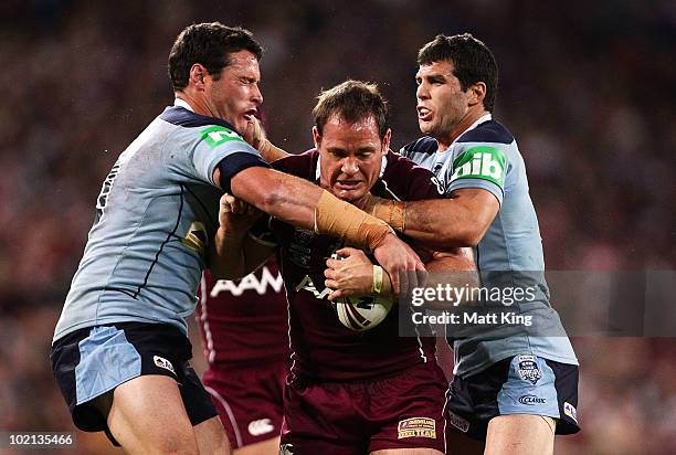 Matthew Scott of the Maroons is tackled by Brett White and Michael Ennis of the Blues during game two of the ARL State of Origin Series between the...