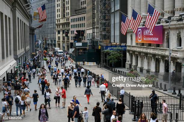 People walk past the New York Stock Exchange , August 22, 2018 in New York City. Today marks the longest bull market rally in U.S. History,...