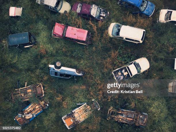 wrecked and abandoned car scrap yard in overgrown vegetation birds eye view - abandoned car stock pictures, royalty-free photos & images