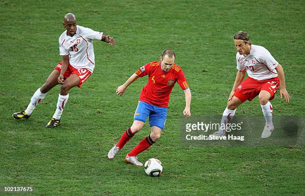 Andres Iniesta of Spain is closed down by Gelson Fernandes and Reto Ziegler of Switzerland during the 2010 FIFA World Cup South Africa Group H match...