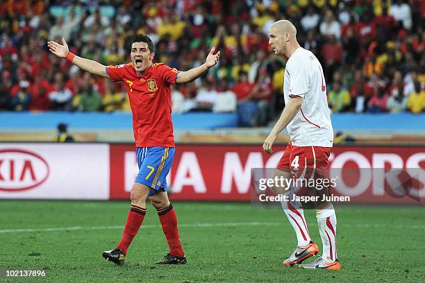 David Villa of Spain reacts as Philippe Senderos of Switzerland looks on during the 2010 FIFA World Cup South Africa Group H match between Spain and...