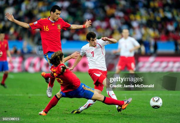 Tranquillo Barnetta of Switzerland comes under pressure from Carles Puyol of Spain during the 2010 FIFA World Cup South Africa Group H match between...