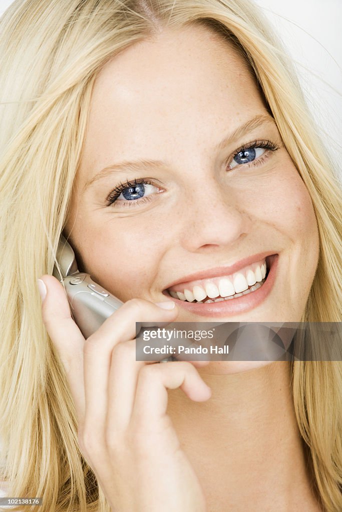 Young woman using mobilephone, smiling