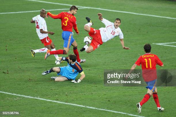 Eren Derdiyok of Switzerland jumps over Iker Casillas of Spain as he rushes out of his goal, which leads up Gelson Fernandes to score during the 2010...