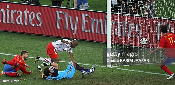 Switzerland's midfielder Gelson Fernandes falls over Spain's goalkeeper Iker Casillas as Fernandes scores a goal during their Group H first round...