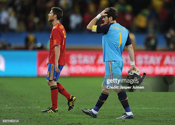 Xabi Alonso and Iker Casillas of Spain walk off the pitch dejected after defeat in the 2010 FIFA World Cup South Africa Group H match between Spain...