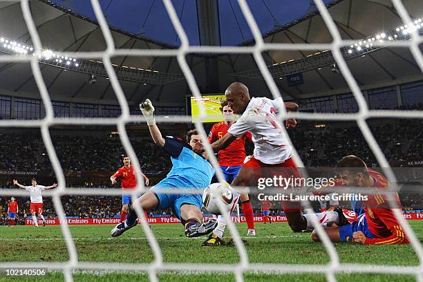Gelson Fernandes of Switzerland scores the first goal under pressure from Iker Casillas and Gerard Pique of Spain during the 2010 FIFA World Cup...