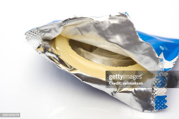 macro view of condom in opened package isolated on white - condom stock pictures, royalty-free photos & images