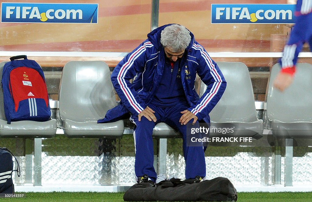 France's coach Raymond Domenech sits on