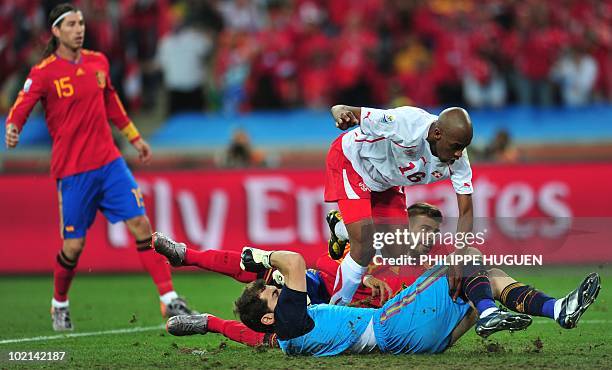 Switzerland's midfielder Gelson Fernandes trips over Spain's goalkeeper Iker Casillas just before Fernandes scores a goal during their Group H first...