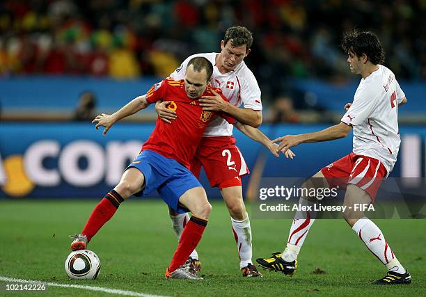 Andres Iniesta of Spain is challenged by Stephan Lichtsteiner and Tranquillo Barnetta of Switzerland during the 2010 FIFA World Cup South Africa...