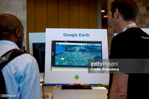 Attendees look at a magnified Google Earth display being run on an HTC smartphone during the Google I/O Developers' Conference in San Francisco,...