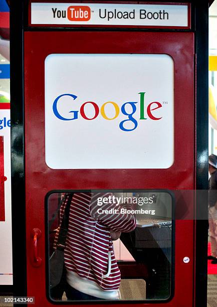 An attendee stands inside a YouTube.com upload booth during the Google I/O Developers' Conference in San Francisco, California, U.S., on Thursday,...