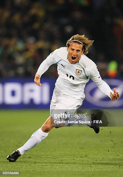 Diego Forlan of Uruguay celebrates after scoring the opening goal during the 2010 FIFA World Cup South Africa Group A match between South Africa and...