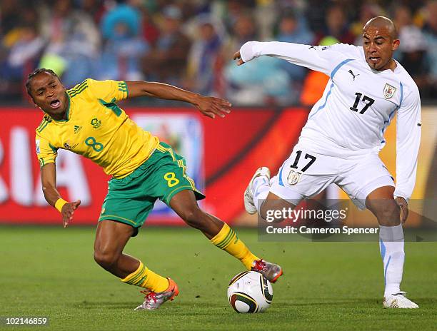 Siphiwe Tshabalala of South Africa tackles Egidio Arevalo of Uruguay during the 2010 FIFA World Cup South Africa Group A match between South Africa...