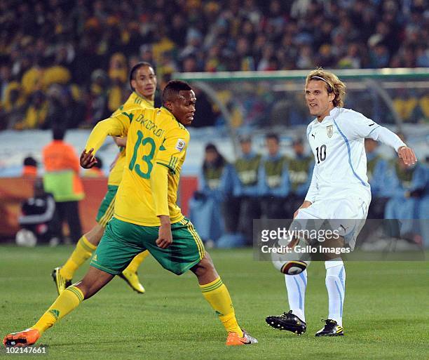 Diego Forlan of Uruguay and Kagisho Dikgacoi of South Africa compete during the 2010 FIFA World Cup Group A match between South Africa and Uruguay...
