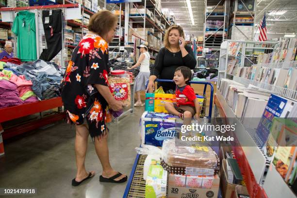 Great-grandmother, Marie Mattson, Anjie Mattson and her grandnephew, Ocean Camacho gather a large cart of supplies in preparation for Hurricane Lane...