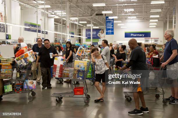 Shoppers with heavily weighted shopping carts wait in line to purchase supplies for Hurricane Lane at Sam's Club on Wednesday, August 22, 2018 in...