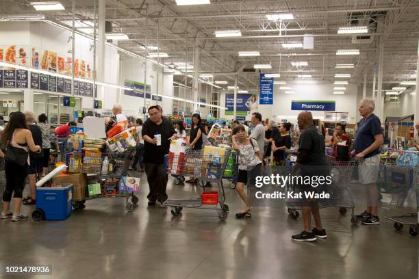 Shoppers with heavily weighted shopping carts wait in line to purchase supplies for Hurricane Lane at Sam's Club on Wednesday, August 22, 2018 in...