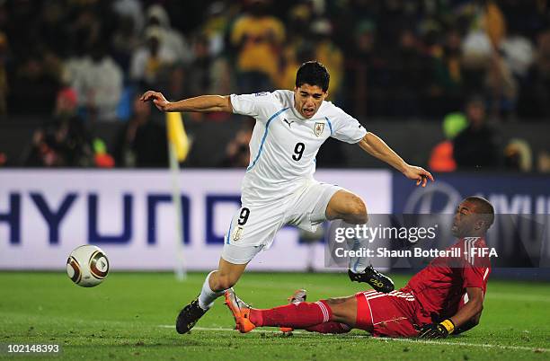 Itumeleng Khune of South Africa tackles Luis Suarez of Uruguay and is sent off straight away during the 2010 FIFA World Cup South Africa Group A...