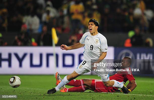 Itumeleng Khune of South Africa tackles Luis Suarez of Uruguay and is sent off straight away during the 2010 FIFA World Cup South Africa Group A...