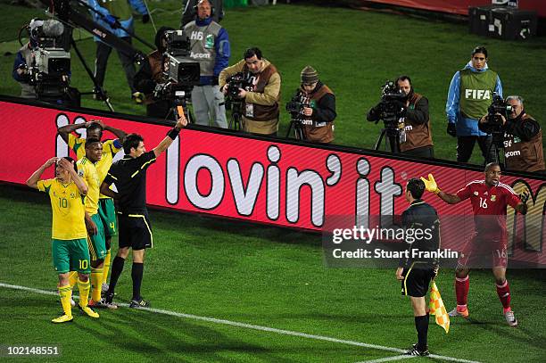 Referee Massimo Busacca sends goalkeeper Itumeleng Khune off with a red card following a challenge on Luis Suarez of Uruguay during the 2010 FIFA...