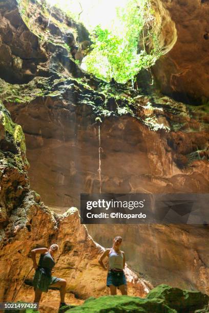 persons posing at a cave - höhlenforscher stock-fotos und bilder