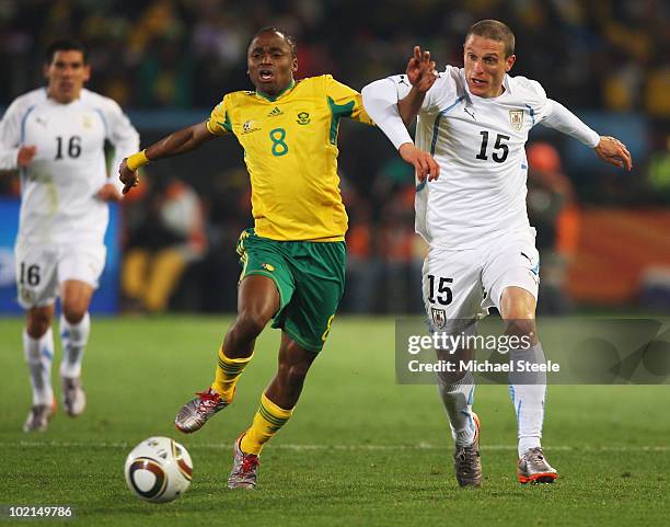 Siphiwe Tshabalala of South Africa tussles with Diego Perez of Uruguay during the 2010 FIFA World Cup South Africa Group A match between South Africa...