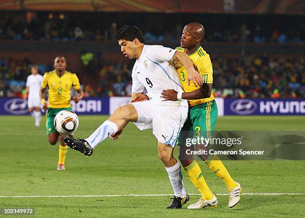 Luis Suarez of Uruguay backs into Tsepo Masilela of South Africa during the 2010 FIFA World Cup South Africa Group A match between South Africa and...