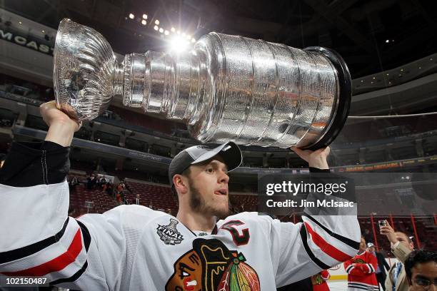 Jonathan Toews of the Chicago Blackhawks hoists the Stanley Cup after teammate Patrick Kane scored the game-winning goal in overtime to defeat the...