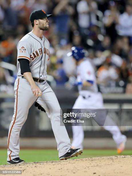 Hunter Strickland of the San Francisco Giants reacts as Todd Frazier of the New York Mets rounds third base after he hit a solo home run in the...