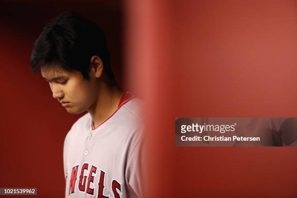 Shohei Ohtani of the Los Angeles Angels warms up in the dugout during the sixth inning of the MLB game against the Arizona Diamondbacks at Chase...