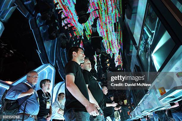 People try out the Disney TRON game at the SIMS exhibit in the annual Electronic Entertainment Expo at the Los Angeles Convention Center on June 16,...