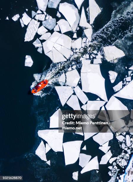 wintery top-down aerial view of red ice-breaker pushing through cracked ice on baltic sea around helsinki - ice breaker stock pictures, royalty-free photos & images