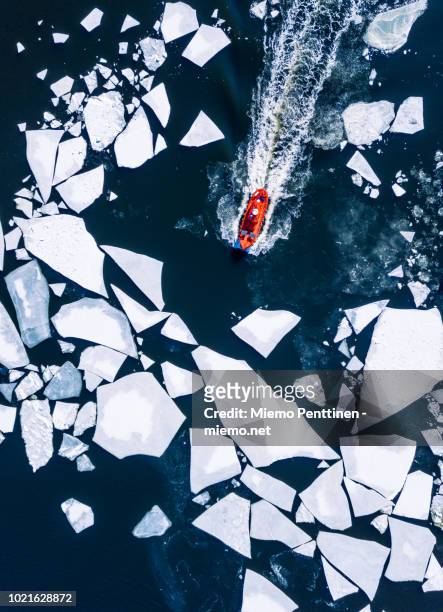 wintery top-down aerial view of red ice-breaker pushing through cracked ice on baltic sea around helsinki - ship stock pictures, royalty-free photos & images