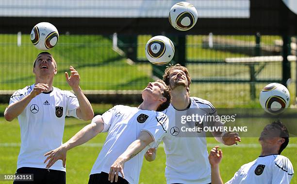 Germany's striker Lukas Podolski, defender Marcell Jansen, defender Arne Friedrich and midfielder Piotr Trochowski warm up with the ball during a...