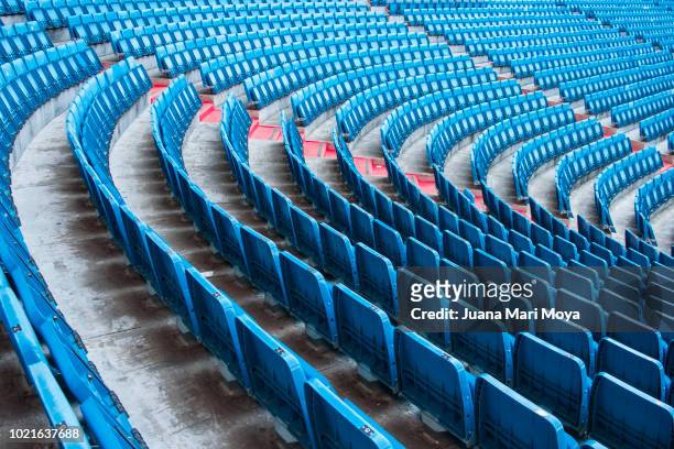 numerous seats on the football field form a photographic composition in a curve. - empty stadium stock pictures, royalty-free photos & images