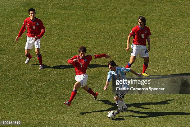 Lionel Messi of Argentina is pursued by Park Ji-Sung of South Korea during the 2010 FIFA World Cup South Africa Group B match between Argentina and...