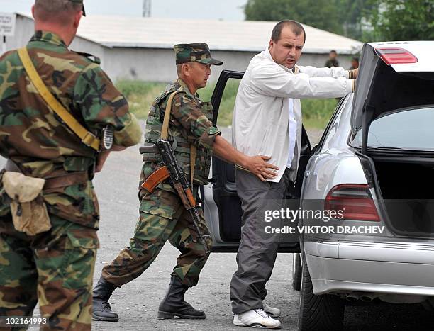 Kyrgyzs special police officer searches a driver at a check point in Osh on June 17, 2010. Deadly inter-ethnic clashes that erupted in Kyrgyzstan a...